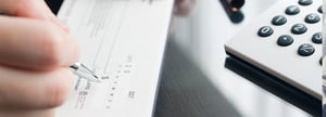 A customer fills out a paper check for payment.